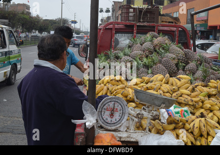 Les ananas et les bananes en vente à partir de l'arrière d'un camion en face d'un marché dans le quartier de Los Olivos Lima, Pérou Banque D'Images