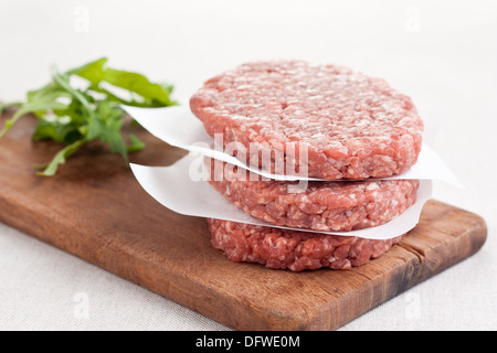 Pile de trois hamburgers crus Banque D'Images