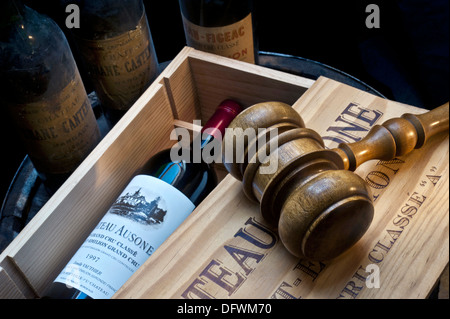 Cave de vente aux enchères de vin avec gavel sur caisse ouverte de Château Ausone Saint-Émilion vin rouge et autres vieux Bordeaux rouge fin Bouteilles de vin derrière la France Banque D'Images