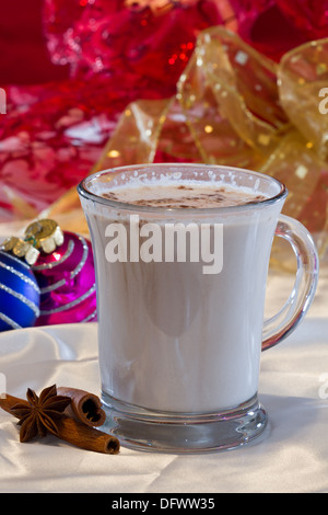 Chocolat blanc chaud servi avec des bâtons de cannelle et anis étoile sur un fond de Noël Banque D'Images