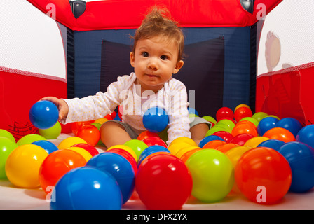 Petit garçon dans un parc pour enfants jouant avec des boules Banque D'Images