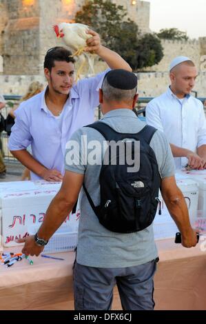 Kapparot - l'un des rituels juifs à la veille du jour saint de Yom Kippour. Dans ce rituel, qui n'est pratiquée que par une fraction de personnes, une personne un poulet cercles trois fois autour de la tête d'une autre personne tout en priant, comme on peut le voir sur cette photographie du 12 septembre 2013. Les péchés de la personne doit transmettre à la poule et ils commencent une nouvelle année sans péchés, le poulet est abattu plus tard et est donné aux pauvres. Photo : Matthias Tödt Banque D'Images