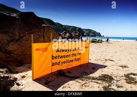 Signe de la RNLI pour avertir les baigneurs de nager entre les drapeaux jaunes sur Plemont beach Jersey CI Banque D'Images