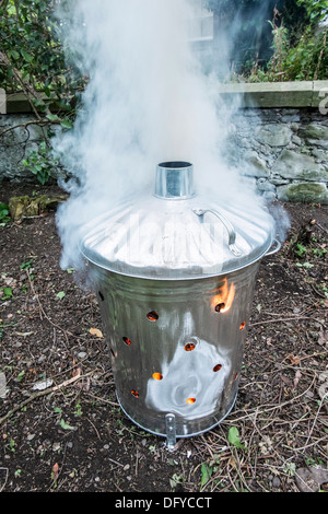 Incinérateur de déchets de jardin de l'élimination de la litière et de brindilles, feuilles - suppression d'un parterre de fleurs. Avec la fumée. Banque D'Images