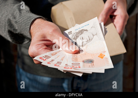 Gros plan de Man Hand tenant des notes anglaises de dix livres Billet de banque en espèces 10 livres sterling billets de banque et enveloppe marron Angleterre Royaume-Uni Royaume-Uni Grande-Bretagne Banque D'Images