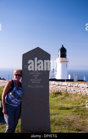 Woman leaning on pierres sculptées à Dunnett head point, point le plus au nord de Grande-Bretagne Banque D'Images