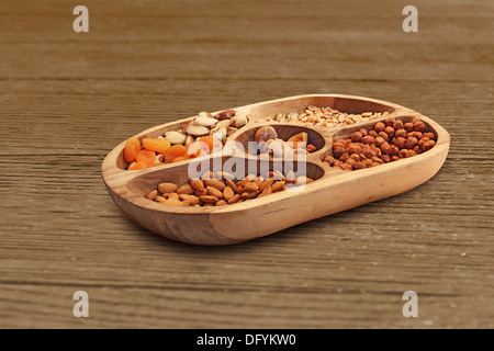Les noisettes, amandes et autres fruits secs dans un bol en bois Banque D'Images