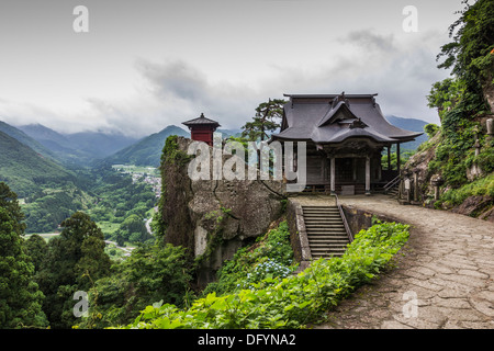 Une photo de Yamadera temple, le Japon. Un bâtiment traditionnel en bois au premier plan, dans le contexte magnifique paysage rural. Banque D'Images