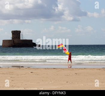 Les sauveteurs RNLI sur St Ouen Jersey plage & La Rocco tower Channel Islands Banque D'Images