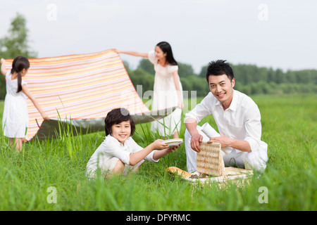 Happy Family un pique-nique sur l'herbe Banque D'Images