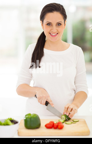 Portrait of pregnant woman cutting vegetables Banque D'Images