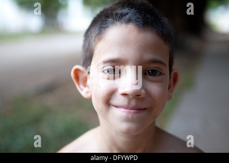 Close up of Hispanic boy standing dans son quartier au crépuscule. Banque D'Images