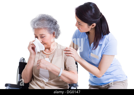 Femme qui allaite réconfortant des pleurs senior woman Banque D'Images