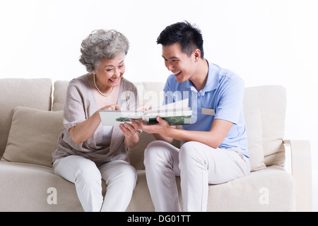 Soins infirmiers et travailleur masculin senior woman looking at photo album Banque D'Images