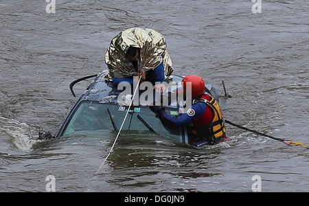 Rudratshofen, Allemagne. Oct 11, 2013. Un chauffeur attend d'être secouru sur le toit de sa voiture au milieu de la rivière Wertach près de Rudratshofen, Allemagne, 11 octobre 2013. L'homme a glissé de la route couverte de neige glissante et dans la rivière. Il a pu être sauvé du toit de sa voiture. Photo : Thorsten Bringezu/dpa/Alamy Live News Banque D'Images