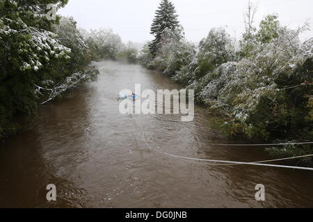 Rudratshofen, Allemagne. Oct 11, 2013. Un chauffeur attend d'être secouru sur le toit de sa voiture au milieu de la rivière Wertach près de Rudratshofen, Allemagne, 11 octobre 2013. L'homme a glissé de la route couverte de neige glissante et dans la rivière. Il a pu être sauvé du toit de sa voiture. Photo : Thorsten Bringezu/dpa/Alamy Live News Banque D'Images