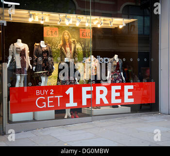 Acheter 2 get 1 free poster à Manchester, UK 10 Octobre, 2013. BOGOF Bargains symptômes au cours de Vogue fashion's Night Out, une charge d'une nuit seule après-travail événement shopping s'installe à Manchester, à partir de Londres, pour la première fois. Plus de 150 détaillants du centre-ville, boutiques, marchés en plein air ouvert jusque tard dans la nuit. Le Cœur de Manchester women's fashion Retail Business Improvement District (BID) et pris en charge le jeu CityCo, événement à la position que le Manchester UK's leading retail destination hors de Londres. Banque D'Images