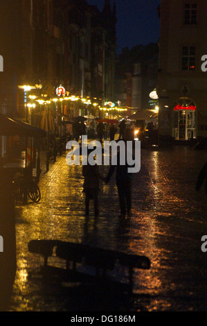 Un couple avec des parapluies dans une douche à effet pluie dans la nuit à Heidelberg, Bade-Wurtemberg, Allemagne Banque D'Images