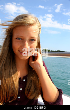 Jeune fille blonde gaie sur des navires en mer Banque D'Images