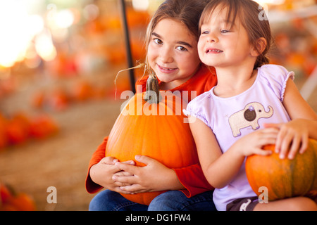 Cute Little Girls Holding leurs citrouilles à une citrouille un jour d'automne. Banque D'Images