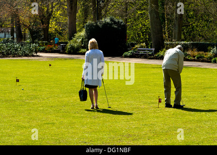 Couple de personnes âgées jouant et parcours de golf sur un parcours en miniature Leys Hall Park Matlock Derbyshire, Angleterre, Royaume-Uni Banque D'Images