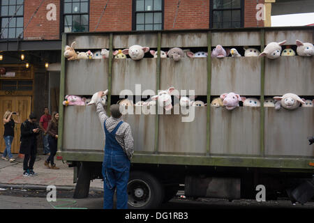 New York, NY, USA. Oct 11, 2013. Les amateurs de Banksy, affluent à l'Meatpacking District de New York, le vendredi 11 octobre 2013 pour voir la onzième tranche de l'art de Banksy, 'les sirènes des agneaux'. Cette pièce sculpturale se compose d'un abattoir camion rempli de bêlements peluches, contrôlée par les marionnettistes, qui ont été conduits autour d'un chauffeur, centre, qui sont restés dans le caractère. Credit : Frances Roberts/Alamy Live News Banque D'Images