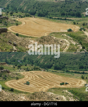 Le nord-ouest de l'Espagne - harvest vu du château de Montéaragon près de Huesca - John Deere machines dans un petit champ Banque D'Images