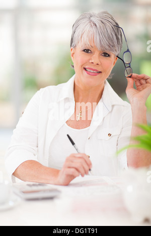 Happy senior woman doing home finances Banque D'Images