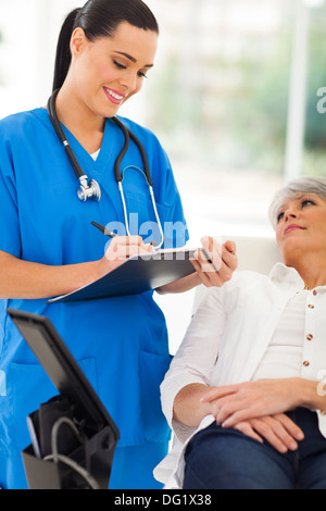 Belle de faire senior patient's checkup in office Banque D'Images