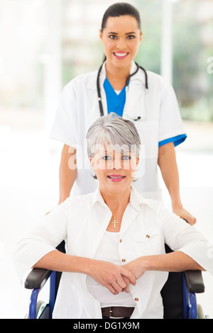Friendly infirmière médicale en prenant soin de senior patient in wheelchair Banque D'Images