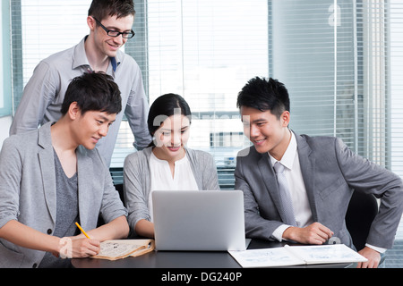 Les jeunes travailleurs de bureau using laptop Banque D'Images