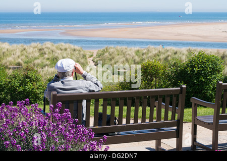 Homme assis sur le banc et regardant la mer Blackpool Lancashire England, UK Banque D'Images