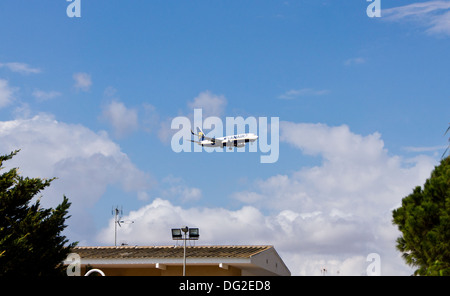 Un avion de Ryanair en provenance des terres dans la distance au-dessus des toits Banque D'Images