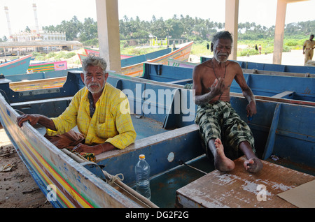 Un pêcheur avec jambes atrophiés à cause de la poliomyélite à Vizhinjam port de pêche, Kerala, Inde Banque D'Images