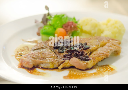 Steak de porc rôti servi avec une purée de pommes de terre et légumes frais Banque D'Images