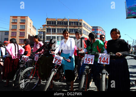 El Alto, Bolivie. 12 octobre 2013. Les compétitrices s’alignent avant le début d’une course de vélos Cholitas pour les femmes indigènes Aymara. La course se déroule à une altitude d'un peu plus de 4 000 m le long des routes principales de la ville d'El Alto (au-dessus de la Paz) pour la Journée des femmes boliviennes, qui était hier vendredi 11 octobre. Crédit : James Brunker / Alamy Live News Banque D'Images