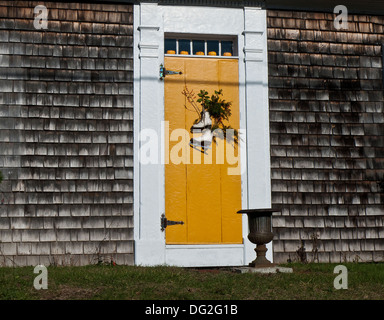 Patins à glace accroché sur la porte jaune. Banque D'Images