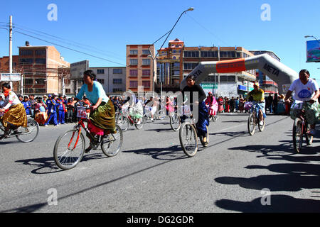 El Alto, en Bolivie. 12 octobre, 2013. Un coureur monte spectactors passé alors qu'elle prend part à une course cycliste pour les Cholitas Aymaras des femmes. La course a lieu à une altitude d'un peu plus de 4 000 m le long des principales routes de la ville de El Alto (au-dessus de la capitale, La Paz) pour la Journée des femmes boliviennes, qui était hier vendredi 11 octobre. Credit : James Brunker / Alamy Live News Banque D'Images