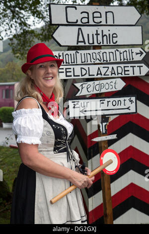 Levisham, Pickering, North Yorkshire, UK. 11 octobre, 2013. Mise en évidence des signes comique avec Tricia Fleming de Retford au chemin de fer en temps de guerre' 'North York Moors Railway (NYMR) Événement à Levisham gare dans le mauvais temps le week-end 12th-13th Octobre 2013. La station de Levisham, a été décoré avec des affiches, et des signes française pendant la guerre (NYMR) 'Week-end' de devenir 'le' Visham dans le nord de la France. Le rassemblement, une reconstitution d'un village occupé par les troupes allemandes, faisant partie de la 'Allo Allo'-style light-hearted et fun humeur. Banque D'Images