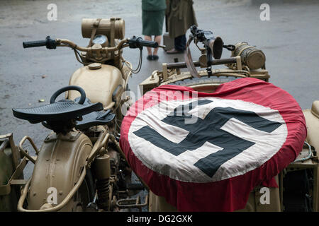 Moto allemande et voiture de tourisme, et drapeau de la croix gammée nazie à l'événement 2013 du « chemin de fer en temps de guerre » North Yworks Moors Railway (NYMR). Levisham Station, a été décoré avec des affiches d'époque, et des panneaux français pendant le «week-end de guerre» (NYMR) pour devenir «le Visham» dans le nord de la France. Le rassemblement, une récréation d'un village français occupé par la Seconde Guerre mondiale, la Seconde Guerre mondiale, la Seconde Guerre mondiale, la Seconde Guerre mondiale, WW2 troupes allemandes. La swastika est un symbole ancien qui était utilisé dans de nombreuses cultures différentes pendant au moins 5 000 ans avant qu'Adolf Hitler n'adopte le drapeau Banque D'Images