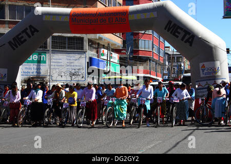 El Alto, Bolivie. 12 octobre 2013. Les compétitrices s’alignent avant le début d’une course de vélos Cholitas pour les femmes indigènes Aymara. La course se déroule à une altitude d'un peu plus de 4 000 m le long des routes principales de la ville d'El Alto (au-dessus de la Paz) pour la Journée des femmes boliviennes, qui était hier vendredi 11 octobre. Crédit : James Brunker / Alamy Live News Banque D'Images