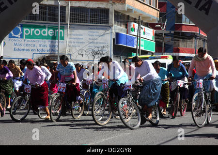 El Alto, Bolivie. 12 octobre 2013. Les compétiteurs commencent une course de vélos Cholitas pour les femmes indigènes Aymara. La course se déroule à une altitude d'un peu plus de 4 000 m le long des routes principales de la ville d'El Alto (au-dessus de la Paz) pour la Journée des femmes boliviennes, qui était hier vendredi 11 octobre. Crédit : James Brunker / Alamy Live News Banque D'Images