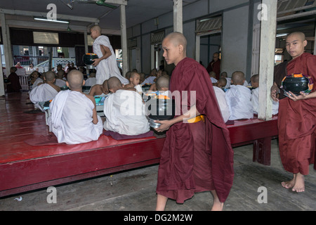 Les moines novices et deux moines âgés dans la salle à manger leur repas de midi, le monastère de Mahagandayon, Amarapura, Myanmar Banque D'Images