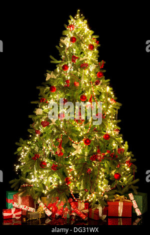 Présente et l'arbre de Noël isolé sur un fond noir Banque D'Images