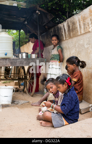 Basse caste indienne children eating dosa pour le petit-déjeuner dans une rue. L'Andhra Pradesh, Inde Banque D'Images