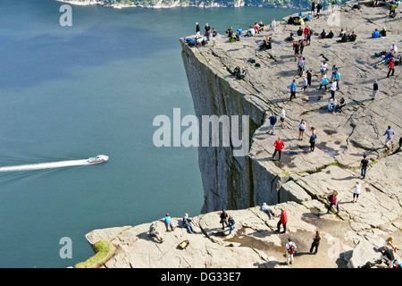 Les touristes et les alpinistes sur le point d'observation Prekestolen (Preikestolen) à près de Stavanger Norvège Lysefjorden avec voile en passant. Banque D'Images