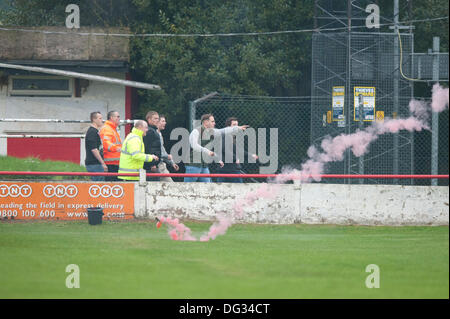 Atherstone, Warwickshire, Royaume-Uni. 12 octobre, 2013. Un groupe de fans à partir de l'extrémité de la route sol Sheepy marcher autour du périmètre de la hauteur et de l'échelle les clôtures pour attaquer le supporters visiteurs (Barrow AFC). Un feu d'artifice a également été lancée en direction de la terrasse de la voiture qui suit. Un drapeau a été volé de la Barrow AFC fans et ensuite mis le feu à l'aide d'un artifice allumé. Atherstone Président Rob Weale a présenté ses excuses pour ce qui s'est produit et a juré de poursuivre les auteurs. Banque D'Images