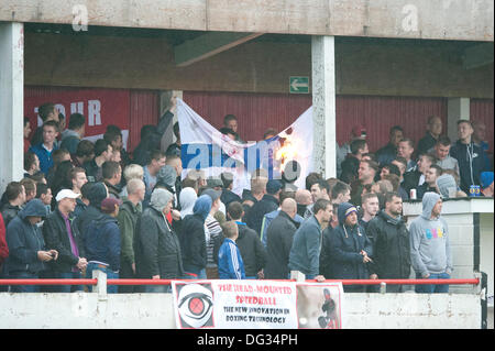 Atherstone, Warwickshire, Royaume-Uni. 12 octobre, 2013. Un groupe de fans à partir de l'extrémité de la route sol Sheepy marcher autour du périmètre de la hauteur et de l'échelle les clôtures pour attaquer le supporters visiteurs (Barrow AFC). Un feu d'artifice a également été lancée en direction de la terrasse de la voiture qui suit. Un drapeau a été volé de la Barrow AFC fans et ensuite mis le feu à l'aide d'un artifice allumé. Atherstone Président Rob Weale a présenté ses excuses pour ce qui s'est produit et a juré de poursuivre les auteurs. Banque D'Images