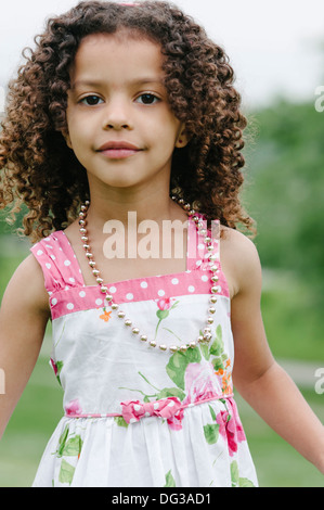 Jeune fille aux cheveux bruns bouclés portant tenue d'été et Collier, Portrait Banque D'Images