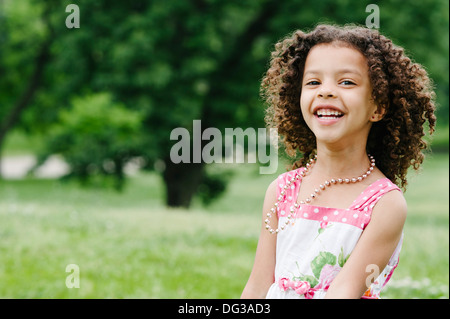 Souriante jeune fille aux cheveux bruns bouclés, Portrait Banque D'Images